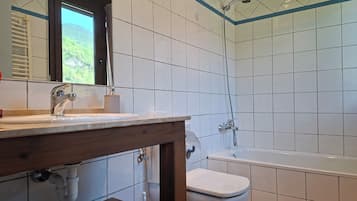 Tweepersoonskamer | Badkamer | Een haardroger, handdoeken, toiletpapier