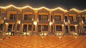 A hotel with a symmetrical facade, multiple windows, and a tiled entrance area. - HYAT LUXURY (Mandarmani)