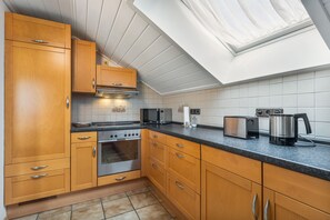 Une cuisine moderne avec des meubles de rangement en bois, un four encastré, un four à micro-ondes et un grille-pain.