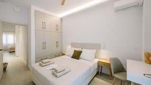 Een moderne hotelkamer met een groot bed, een bureau en een kledingkast.