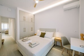 Ein modernes Hotelzimmer mit einem großen Bett, einem Schreibtisch und einem Kleiderschrank.