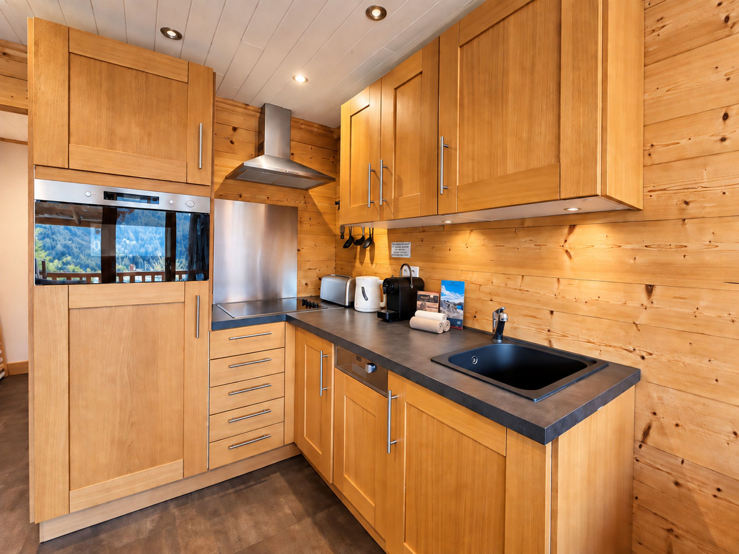 A modern kitchen with wooden cabinetry, stainless steel appliances, and a black countertop.