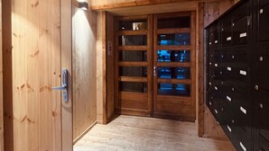 Un interior de madera con una puerta, un conjunto de armarios y una lámpara.