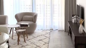 Una sala moderna con un sofá, una mesa de centro, una alfombra y un mueble para televisión.