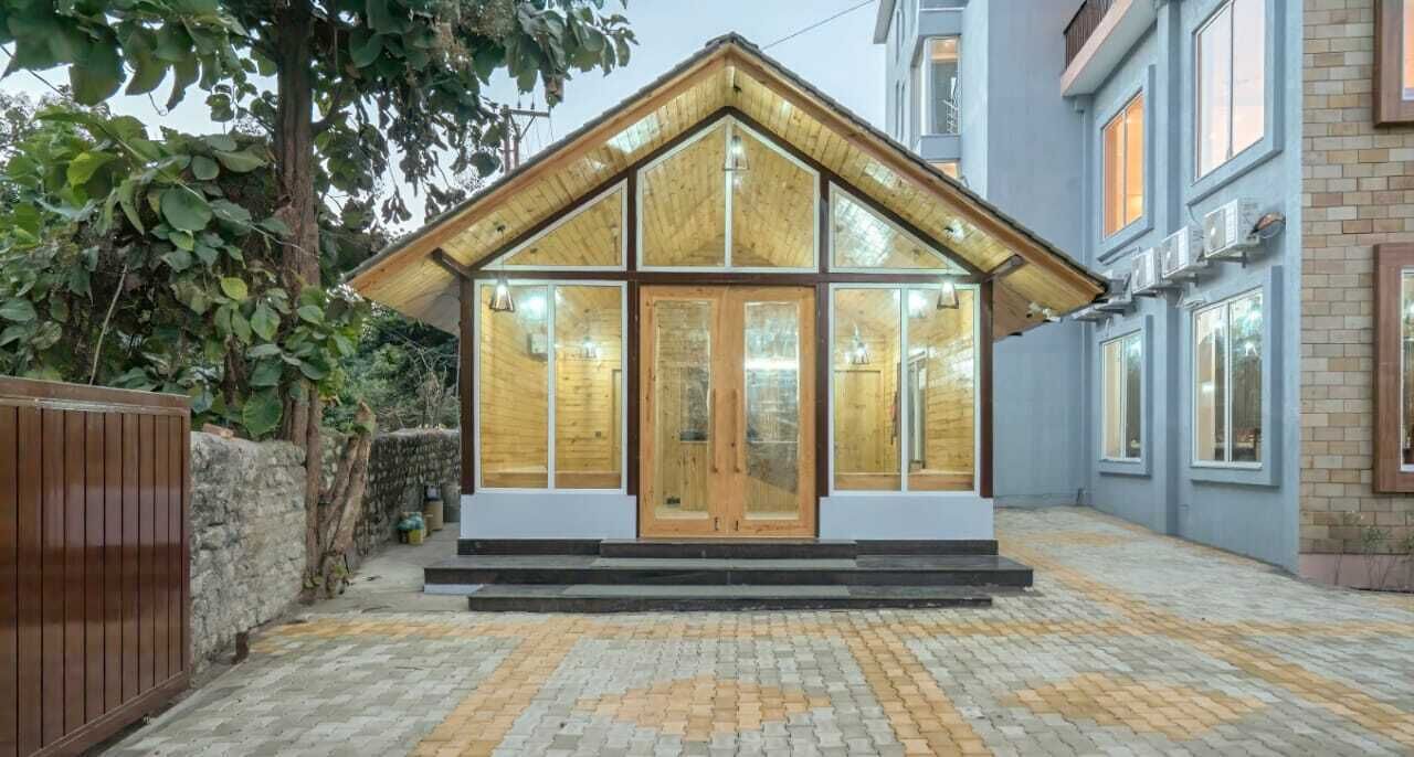 A modern house with a wooden facade, large windows, and a brick pathway leading to the entrance.