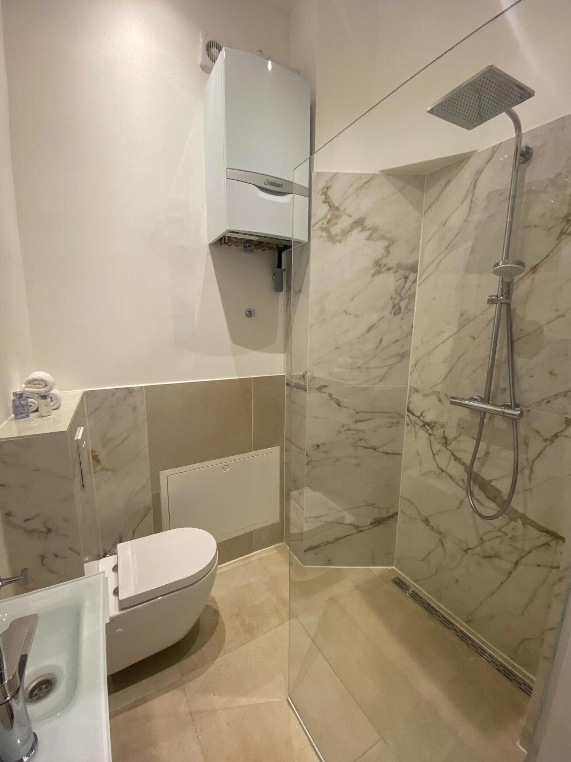 Une salle de bain moderne équipée de toilettes, d’un lavabo et d’une douche.