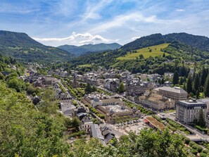 Eine Stadt mit historischer Architektur, umgeben von grünen Hügeln und Bergen.