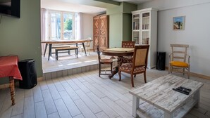 Un comedor con una mesa y sillas de madera, un armario blanco y un televisor montado en la pared.