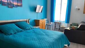 A room with a bed, a desk, a chair, a small table, and a lamp. - 6-person apartment in La Bourboule center (La Bourboule)