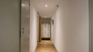 A narrow hallway with wooden flooring and white walls. - Cozy duplex in central La Bourboule, up to 6 people (La Bourboule)