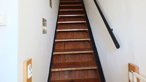 A wooden staircase with a black handrail, white walls, and a door at the top. - 2* Apartment with private garden, 4 people, in La Bourboule (La Bourboule)