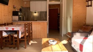 A cozy wooden interior with a dining area, kitchen, and a living space. - Bright studio in Pra-Loup for 4 pers, south balcony (Pra-Loup)