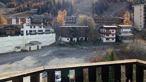 A residential area with modern and traditional buildings, a parking lot, and a mountainous backdrop. - Bright studio in Pra-Loup for 4 pers, south balcony (Pra-Loup)