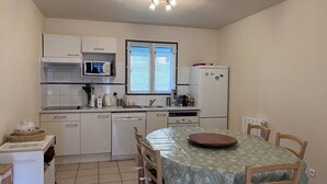 A compact kitchen with white cabinets, a microwave, a refrigerator, and a window with blinds. - Family chalet for 10 people with parking in Cauterets (Cauterets)