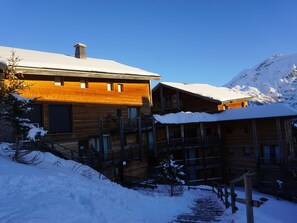 A wooden lodge with multiple balconies and a snow-covered mountain in the background. - Orcières Merlette, 3 rooms, 6 pers, 42m², WIFI, Parking (Orcières Merlette)