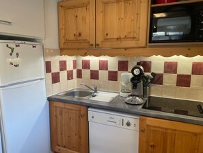 A kitchen with wooden cabinets, a refrigerator, a microwave, a coffee maker, and a dishwasher. - Orcières Merlette, 3 rooms, 6 pers, 42m², WIFI, Parking (Orcières Merlette)