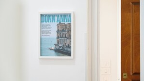 A framed poster of a coastal building with the text "Donn'Anna" on a white wall. - Apartment Donn'Anna Int 14 (Napoli)