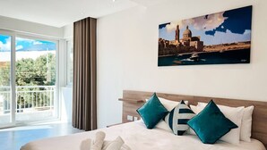A modern hotel room with a large bed, teal pillows, and a cityscape painting on the wall. - Modern Escape Villa with Pool by ArcoCollection (St. Julian`s)