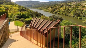 A staircase leading to a terrace with a view of a river and surrounding greenery. - Villa in the Douro - Quinta de Pias. Perfect for families! (Espadanedo)