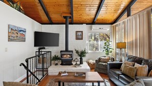 A living room with a fireplace, a sofa, a coffee table, and a TV.