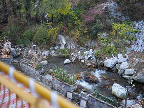 A rocky stream with a stone wall and benches. - Elysian heights (Manali)