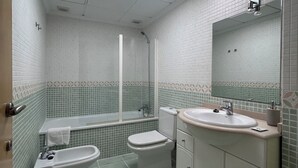 A bathroom with a toilet, bidet, sink, and a mirror. - Nomads' Triangle" Central Park - Ruzafa - Turia (València)