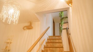A staircase with wooden handrails, a hanging light fixture, and a plant on the wall. - Country house in the Sierra Nevada- Almería. Nature, hiking and relaxation (Abrucena)