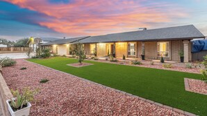 A modern house with a well-maintained lawn, a patio area, and a brick exterior. - Private Hot Tub & Huge Yard: Phoenix Family Home (Phoenix)