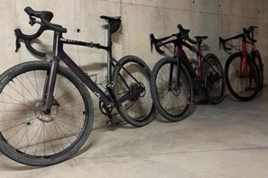 A row of bicycles leaning against a wall in a room. - Elegant Bike & Moto Haven - Monolocale (Gavardo)
