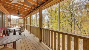 A wooden deck with a table and chairs, a ceiling fan, and a view of trees. - Mount Haven Retreat : Escape With Screened Porch! (Murphy)