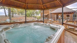 A hot tub area with a wooden deck and a covered seating area. - Lake Eufaula Cabin w/ Dock at Nine Marina (Eufaula)