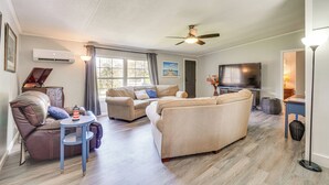 A living room with a sectional sofa, a small round table, a flat-screen TV, and a ceiling fan. - Relax Fireside! Retreat Near Chickamauga Lake (Decatur)