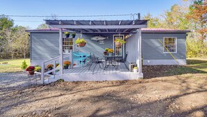 A house with a covered porch, a dining area with a table and chairs, and hanging flower baskets. - Relax Fireside! Retreat Near Chickamauga Lake (Decatur)