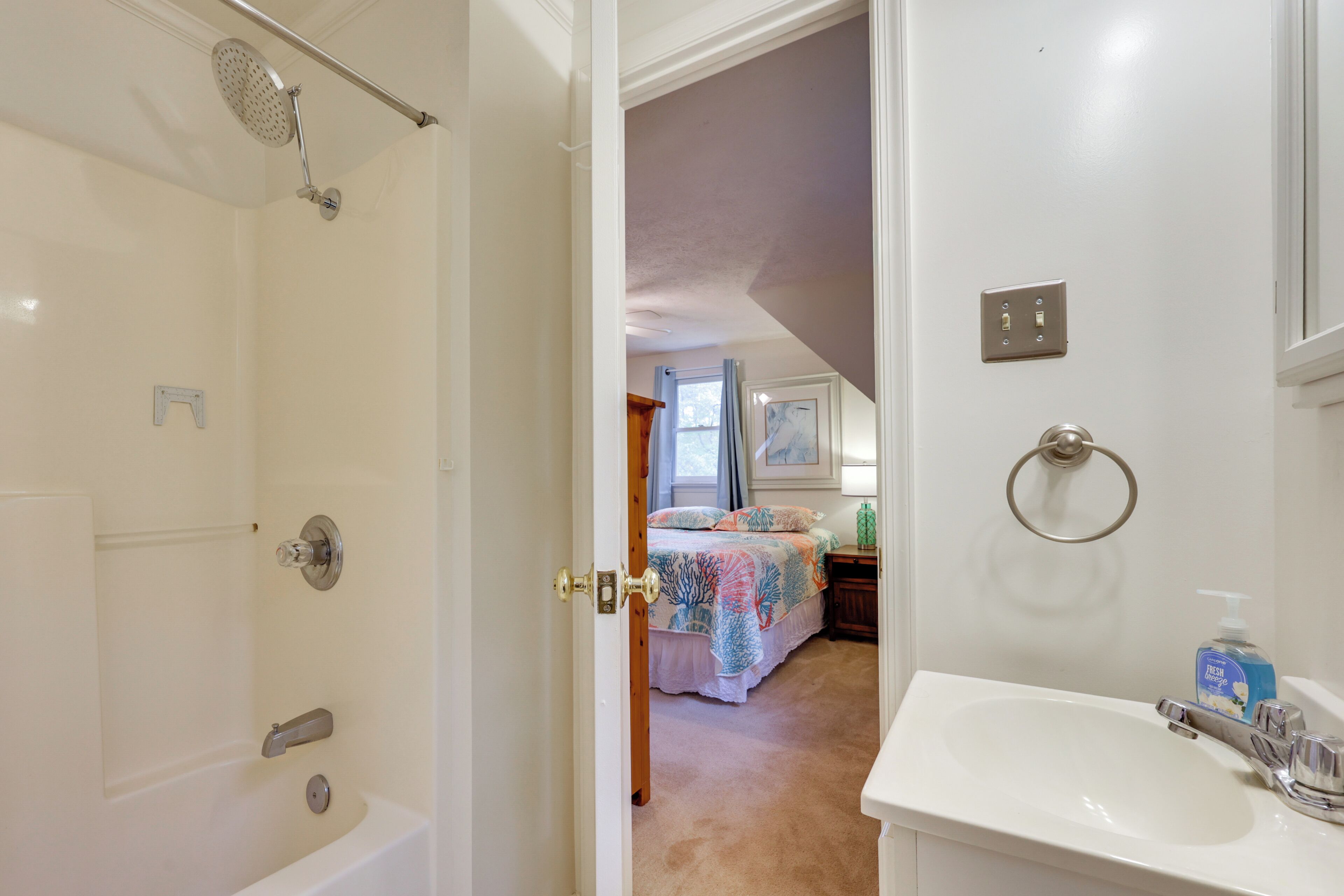 A bathroom with a bathtub, shower, and sink.