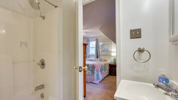 A bathroom with a bathtub, shower, and sink.