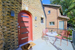 A red door with a mail slot, a small window, and a balcony with a table and two chairs. - Near Casinos & Lake Michigan: Hammond Home! (Hammond)