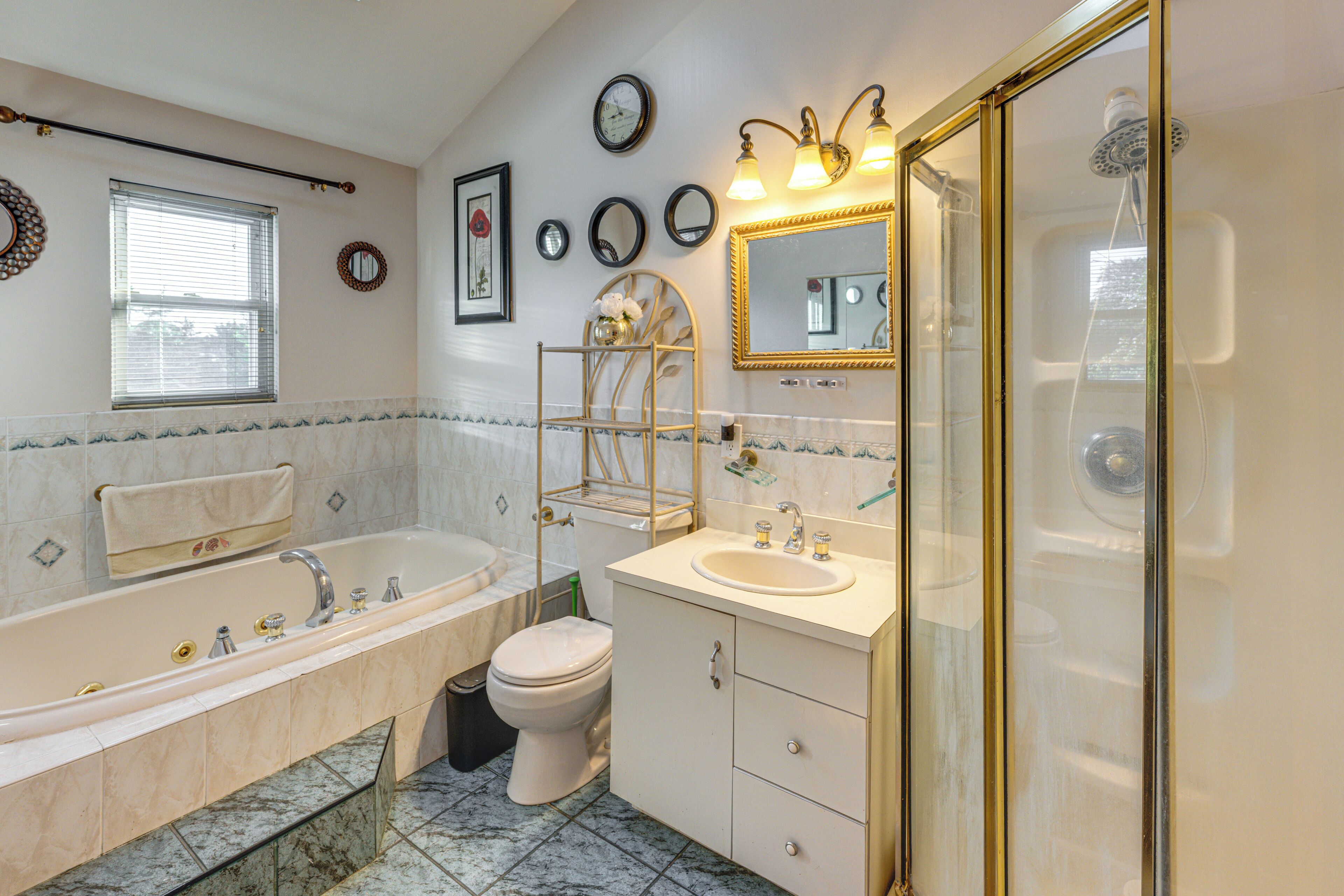 Een badkamer met bad, toilet, wastafel en douche.