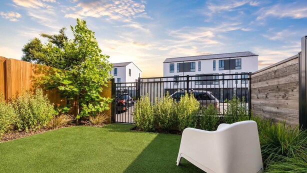 A backyard with artificial grass, a white bench, and a wooden fence. - Cozy Central Loft | Walk to CBD & Stadium (Christchurch)