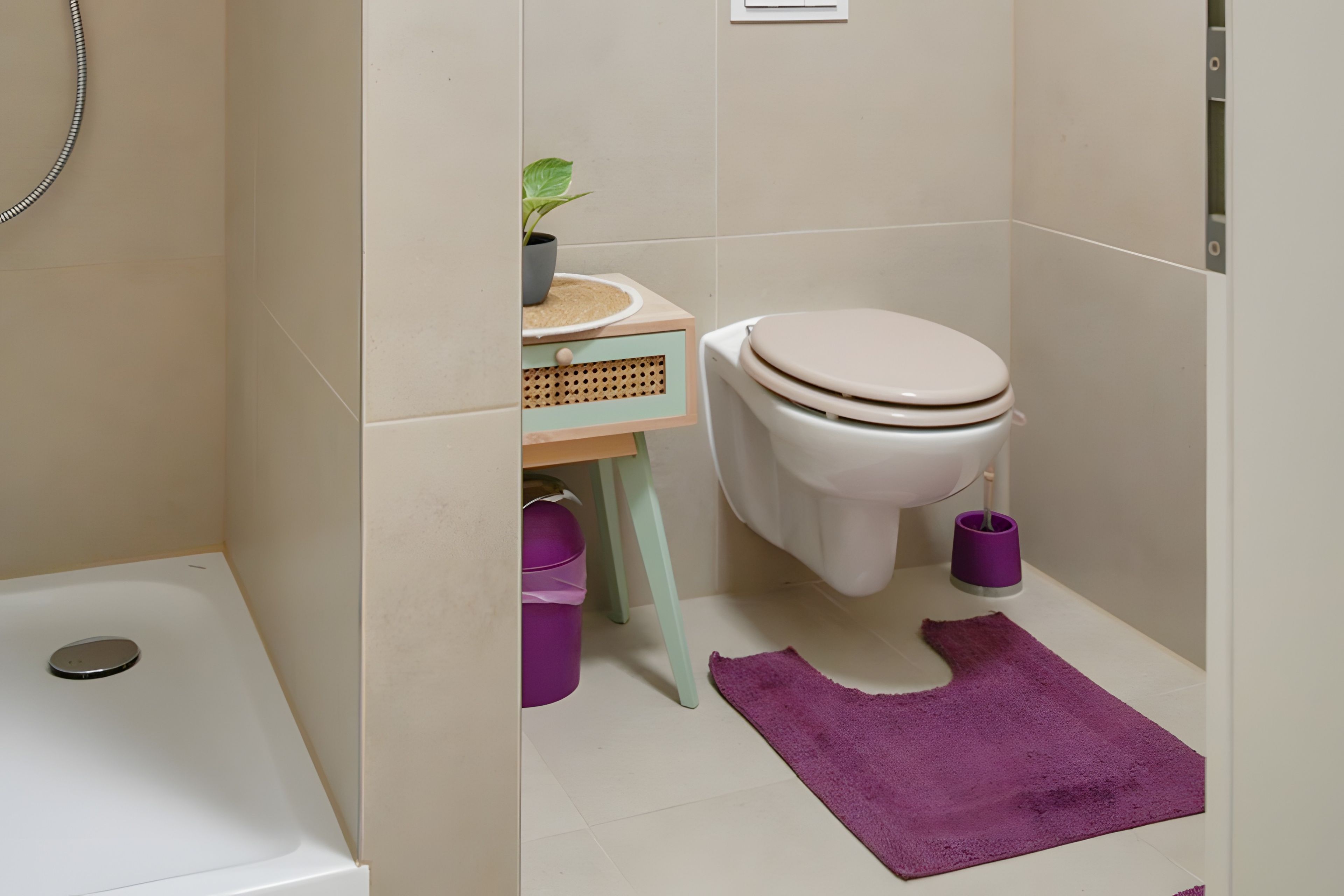 Ein Badezimmer mit Toilette, Bidet, kleinem Waschbecken und Dusche.