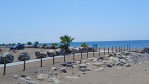 A beach with a parking area, palm trees, and a clear sky. - Vacation Home 'Holiday Esquinita' with Wi-Fi and Air Conditioning (San Bartolomé de Tirajana)
