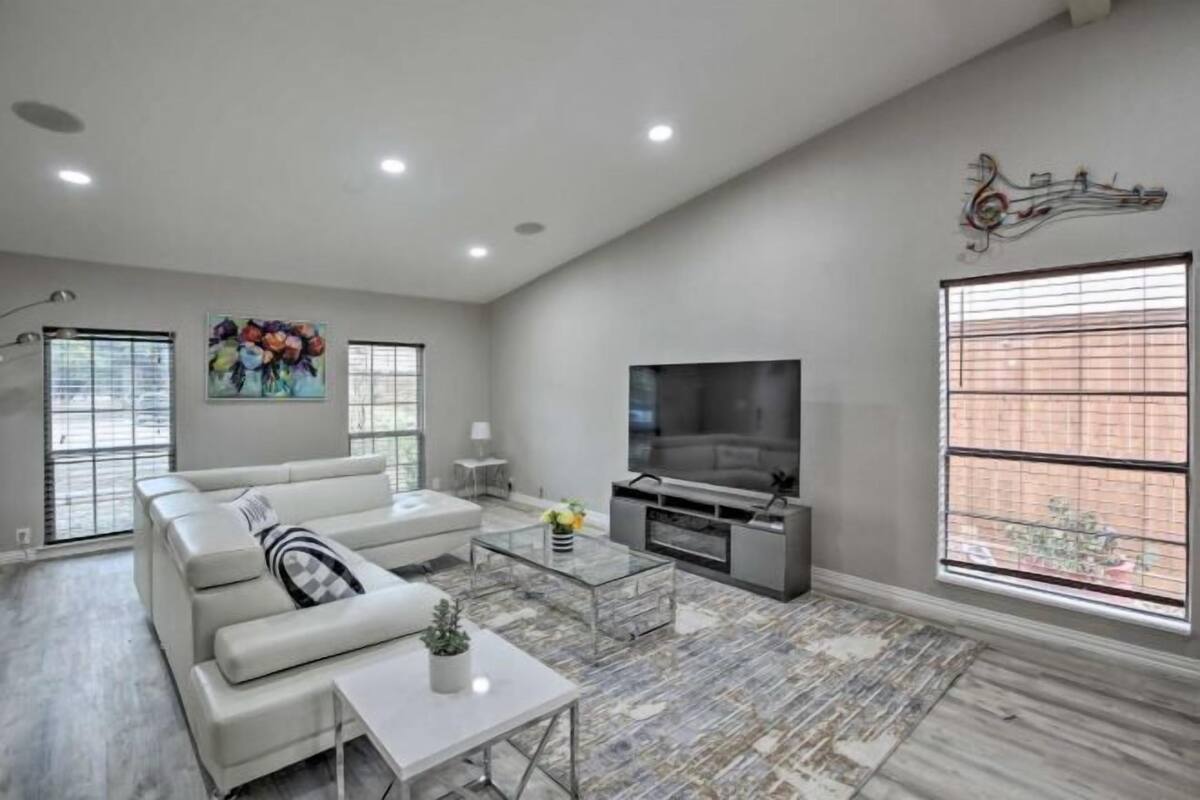 A modern living room with a sofa, coffee table, TV, and artwork.