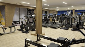 A gym with multiple treadmills, elliptical machines, and a bench press area. - For Students Only - Studios in Cambridge (Cambridge)