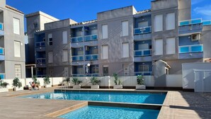 A modern apartment building with a swimming pool, balconies, and potted plants. - Modern Apartment "R-60-B" in Torrevieja (Torrevieja)