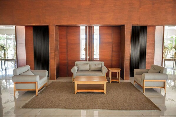 Un lobby moderno con un conjunto de sofás, una mesa de centro y una mesita auxiliar.