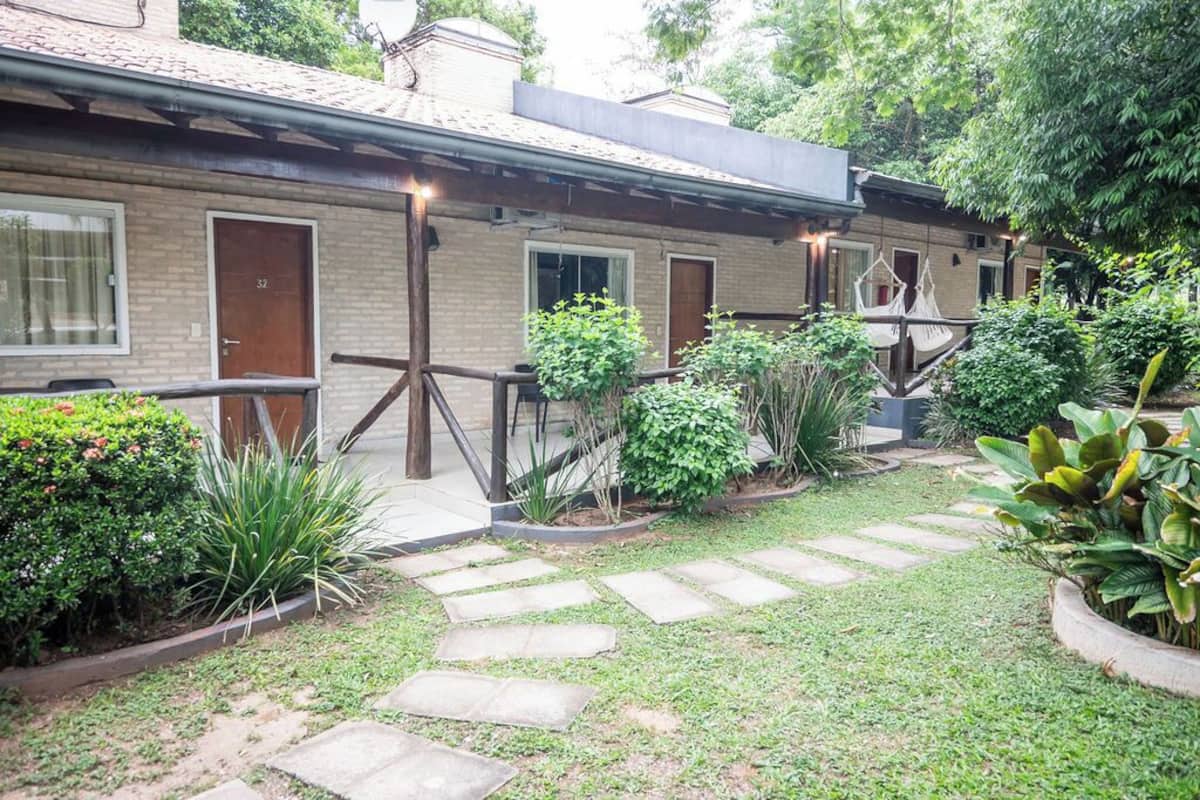 A row of brick buildings with a garden pathway leading to the entrance.