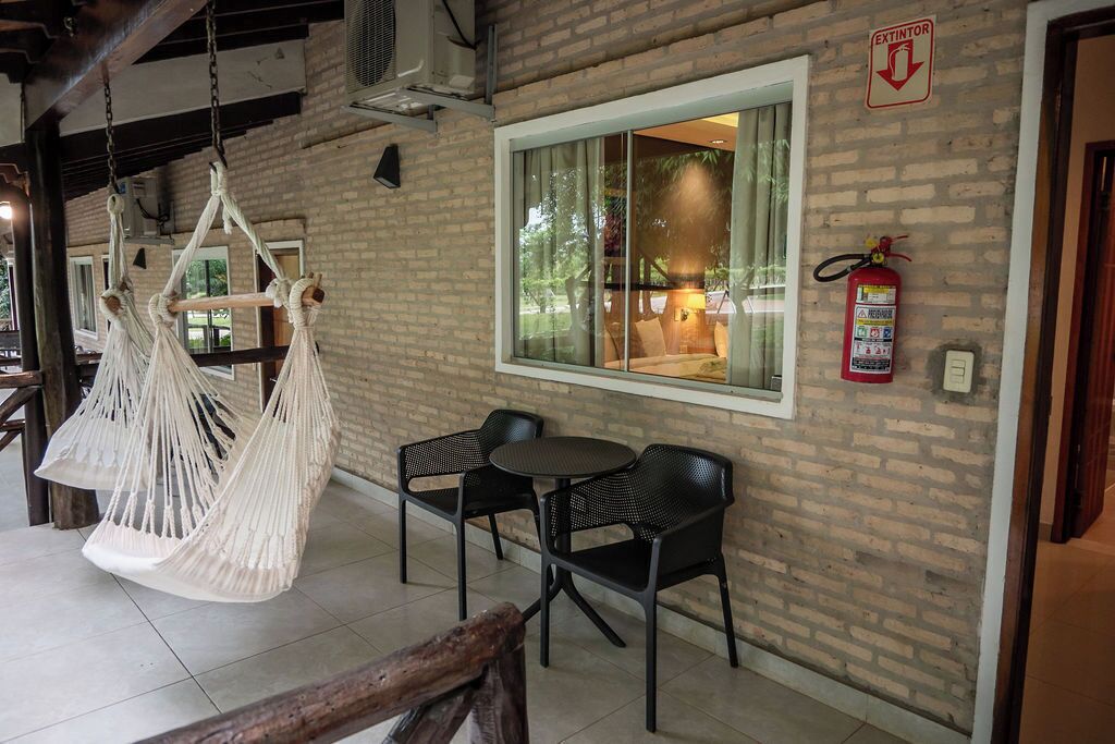 Un área de estar interior acogedora con pared de ladrillo, un ventanal y un extintor.