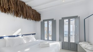 A bedroom with a bed, a window with shutters, and a view of the sea. - Dream Baby with Private Pool (ftelia mykonos)