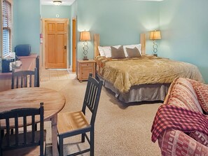 A bedroom with a bed, bedside lamps, a desk, and a chair. - Nantahala Village king suite w/ fireplace, WiFi, and mtn views. Free train, rafting, and zip tix (Bryson City)