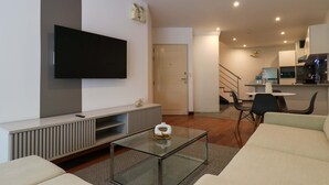 A modern living room with a flat-screen TV, a glass coffee table, and a sofa. - w Graceful 1BR With Balcony in Miraflores (Lima)