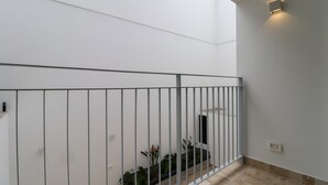 A modern interior with a white wall, a metal railing, and a small plant area. - w Exceptional 2BR With Balcony in San Isidro (Lima)